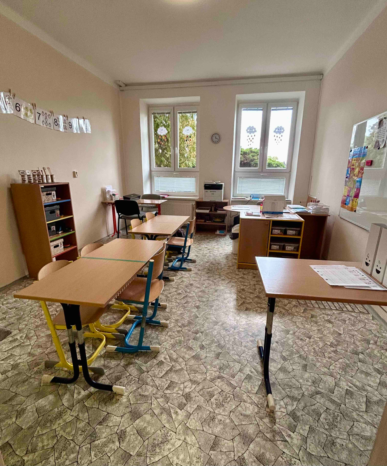 Třída s lavicemi, interaktivní tabulí a nástěnkou s čísly